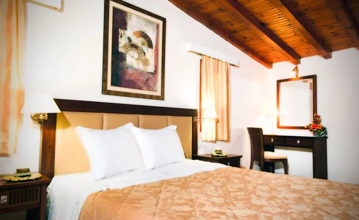 A bedroom under a wooden ceiling